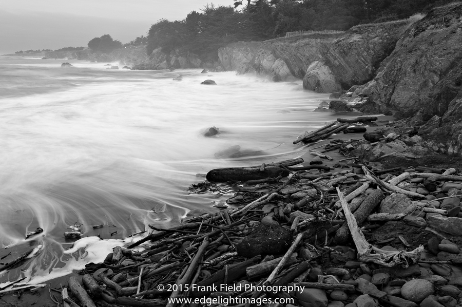 Black and white long exposure photo of rocky shoreline