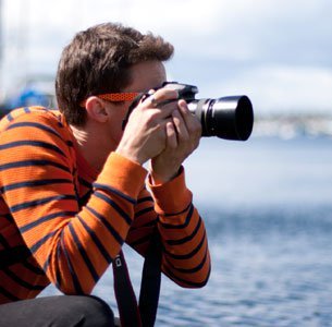 Man with camera wearing a stripped shirt